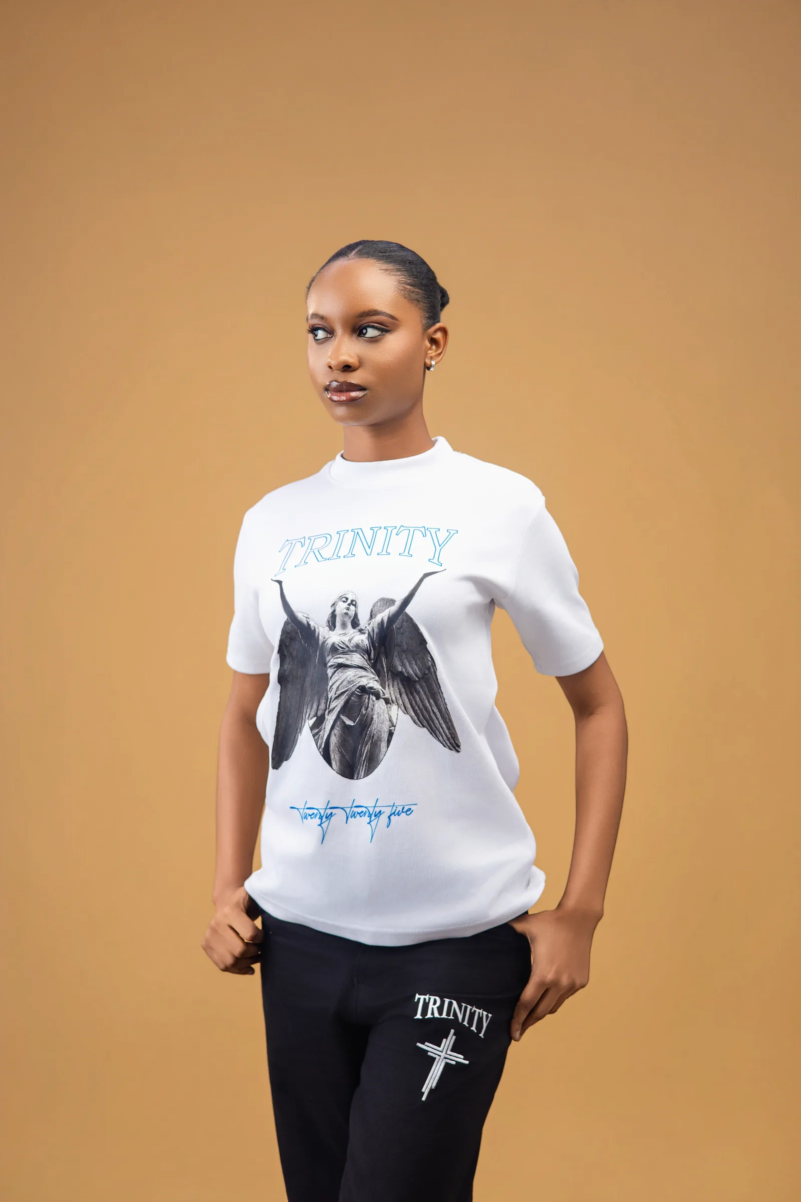 Female model wearing the white shirt with the Trinity angel graphic